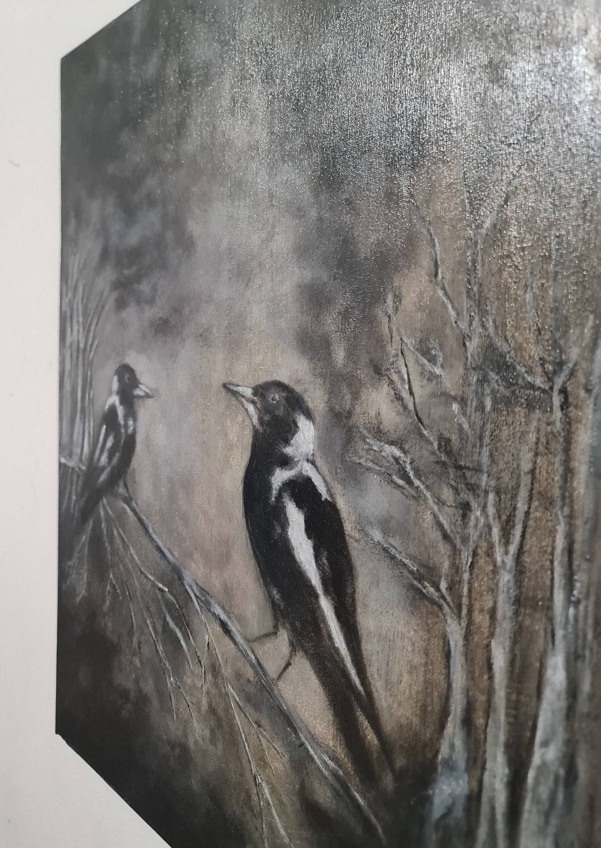 A textured painting of two black-and-white birds perched on bare tree branches against a smoky gray-brown background.