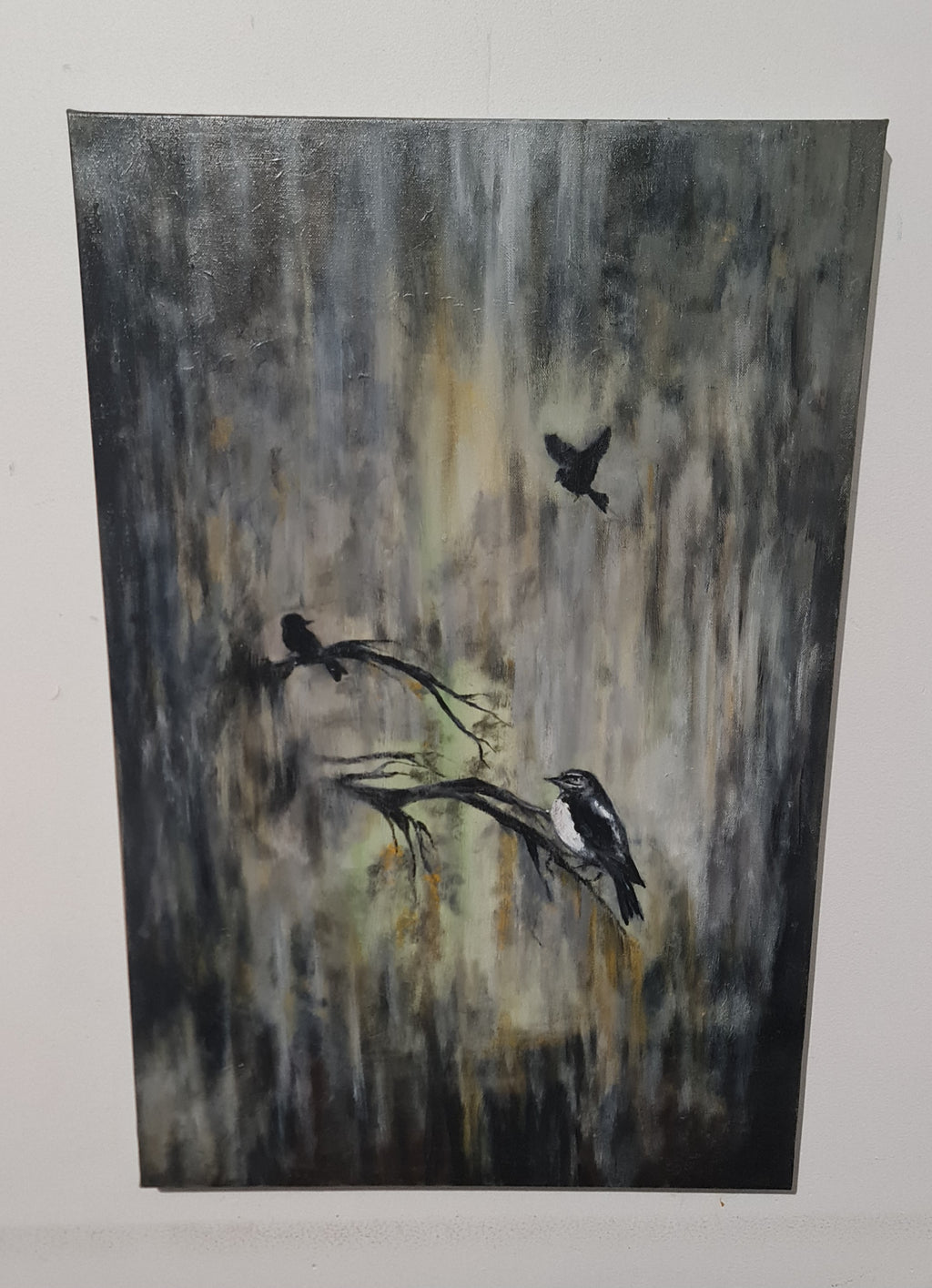 An abstract painting of three birds in black and white perched on branches against a textured gray, black, and beige background, displayed on a white wall.